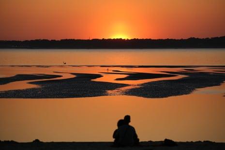People watch the sunset on the Cap Ferret, from a beach of the Arcachon Bay